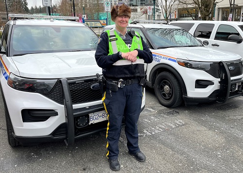Cst. Jen Barker standing beside a marked police vehicle