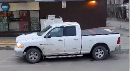 White Dodge Ram with the following features: running boards, black window vents, black tonneau cover, black hood scoop.