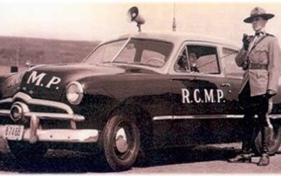 Old RCMP vehicle with member in red serge