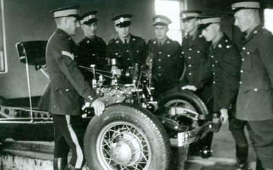 Seven officers in uniform around an old car