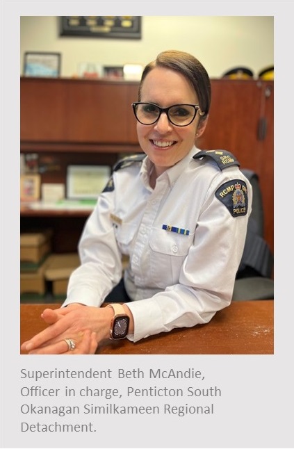 Photo of a Caucasian female sitting at a desk with her hands on the desk crossed wearing a white long sleeve shirt and glasses. Under the photo reads, Superintendent Beth McAndie, Officer in charge, Penticton South Okanagan Similkameen Regional Detachment.