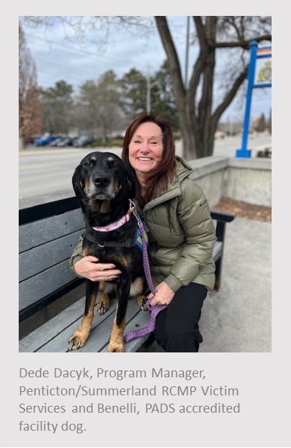 Photo of a Caucasian female sitting on a bench holdin on to a black lab dog in from off an RCMP sign. Text under photogrpah reads, Dede Dacyk, Program Managaer, Penticton / Summerland RCMP Victim Services and Benelli, PADS accredited facility dog.